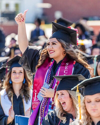 A female Georgia Southern student in graduation robes at commencement.