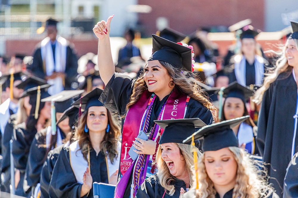 A female Georgia Southern student in graduation robes at commencement.