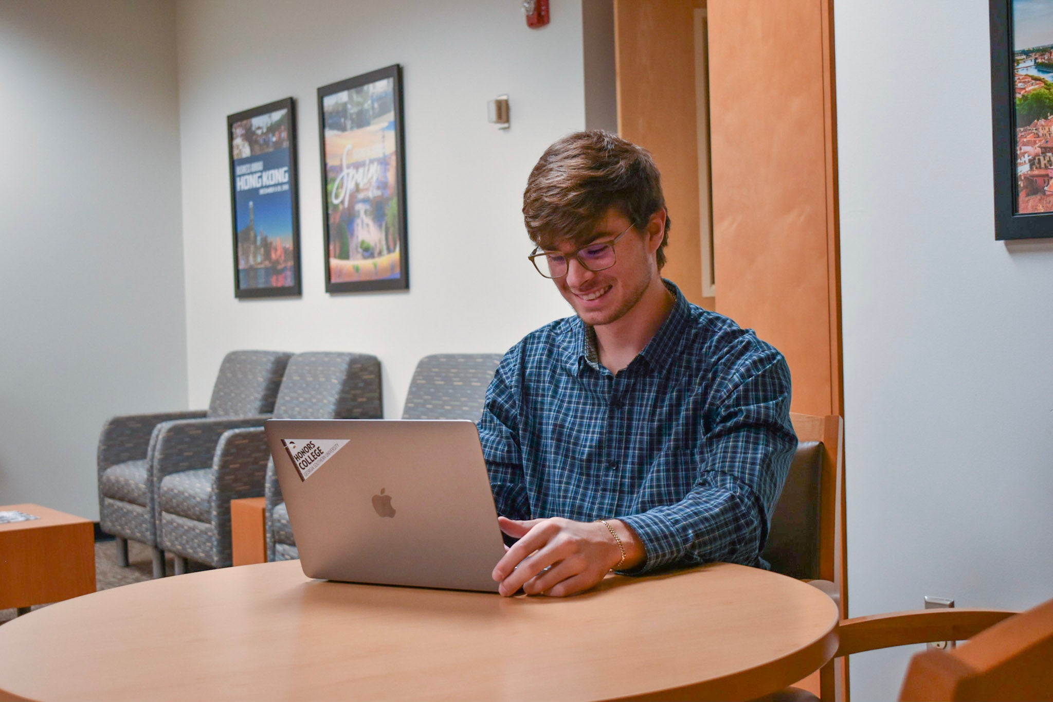 An honors students uses a laptop computer in a seating area.