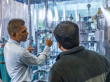 Two Georgia Southern faculty members discuss sustainable fuel alternatives in a research laboratory