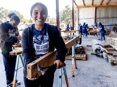 For Vibrant Communities research, a group of Georgia Southern students moves piles of wood boards.