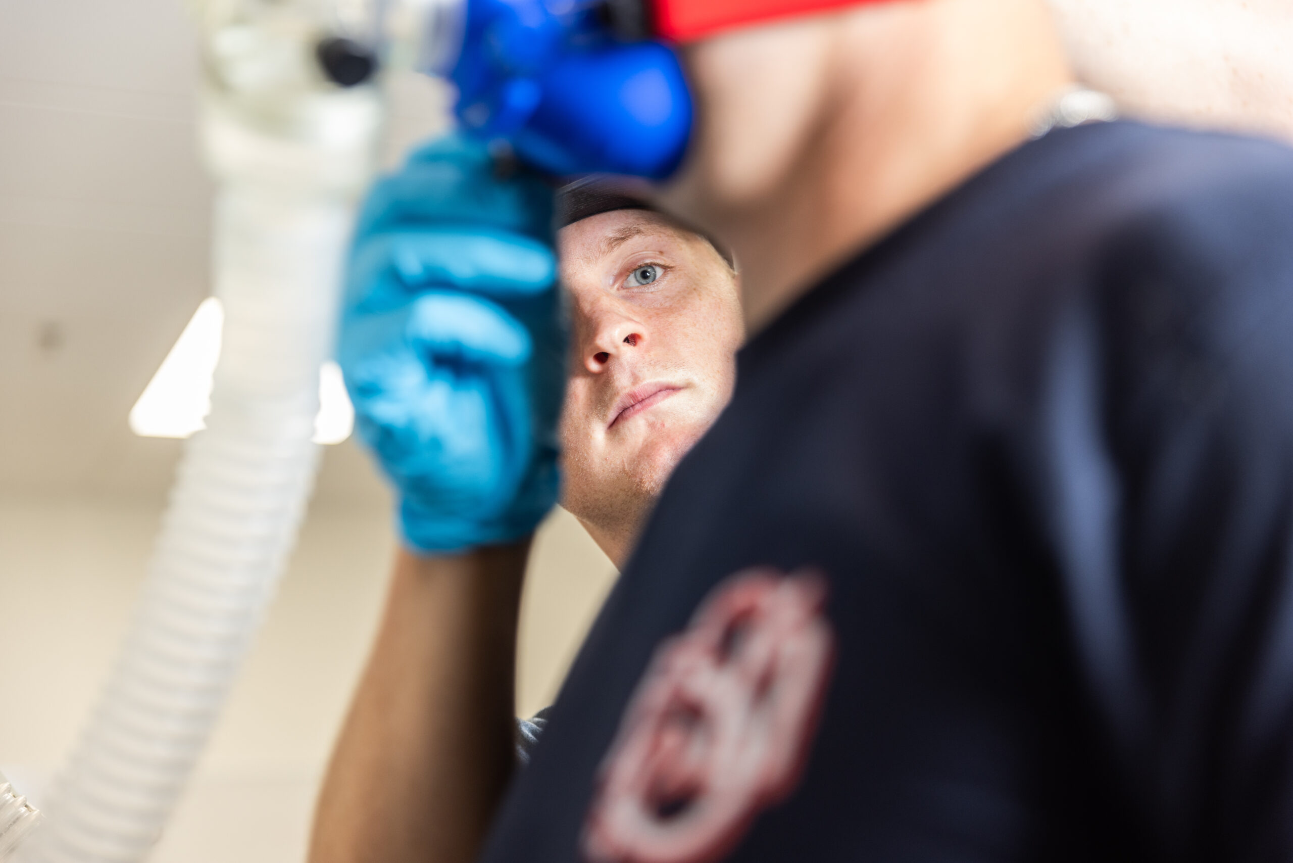 A student adjusts a face mask to study respiratory conditions.