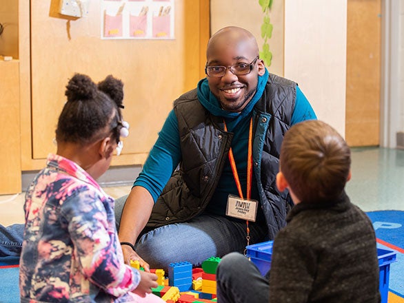 A student teacher from Georgia Southern's College of Education and two elementary grade students play with Legos