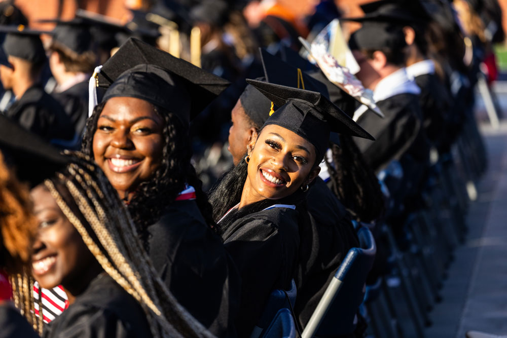 Georgia Southern students in caps and gowns sit in the audience during commencement