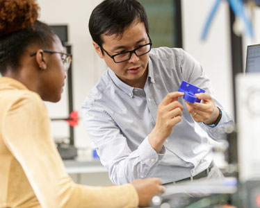 A faculty member from Georgia Southern's Allen E. Paulson College of Engineering explains a concept to a student while holding an object