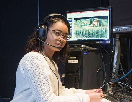 Georgia Southern B.A. in Theatre alum Gabby Scott wears a headset while working behind the scenes