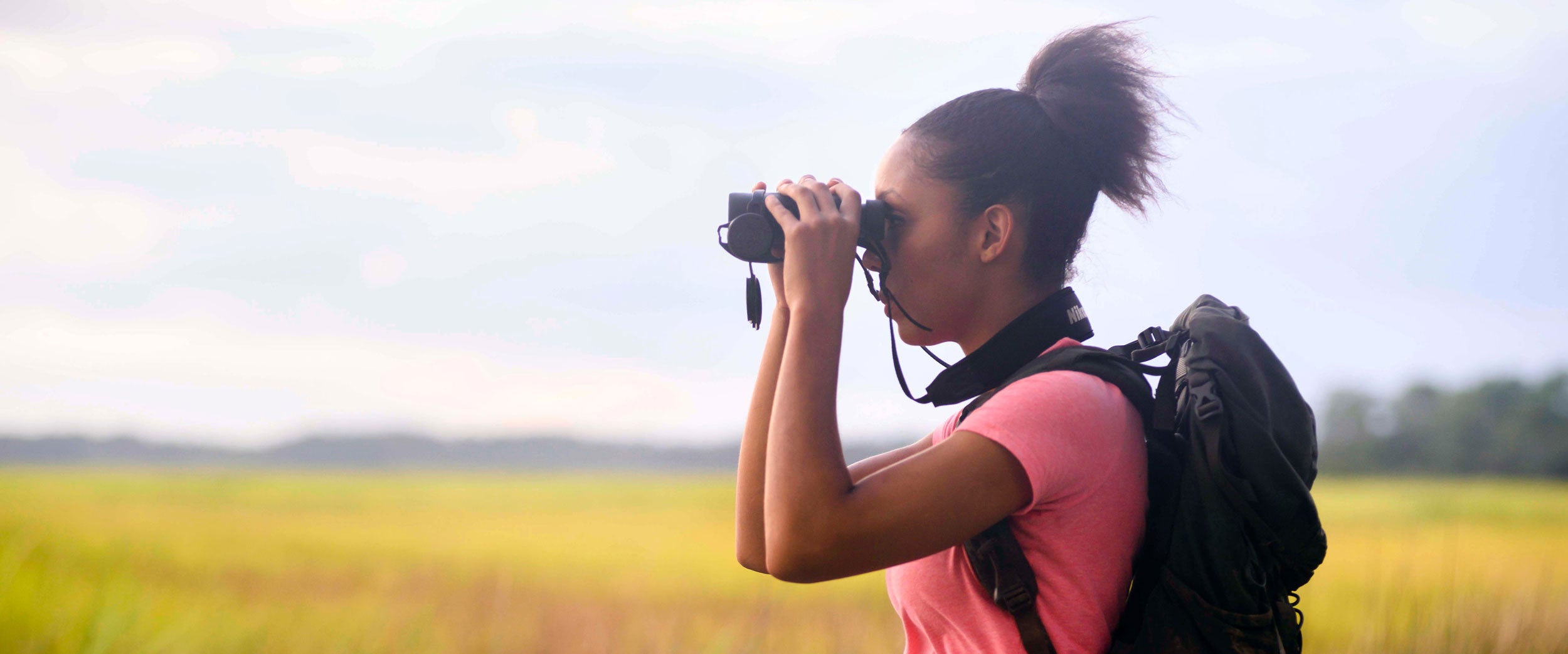 A student from Georgia Southern's B.S. in Geosciences program uses binoculars to survey the surrounding landscape