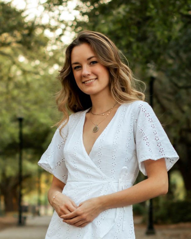 Georgia Southern B.S. in Interior Design alum Emma Franchesina, ‘21 stands near trees outdoors