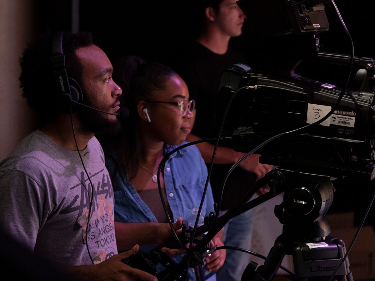 An instructor for Georgia Southern's B.S. in Multimedia and Film Production program helps a student learn to use a camera