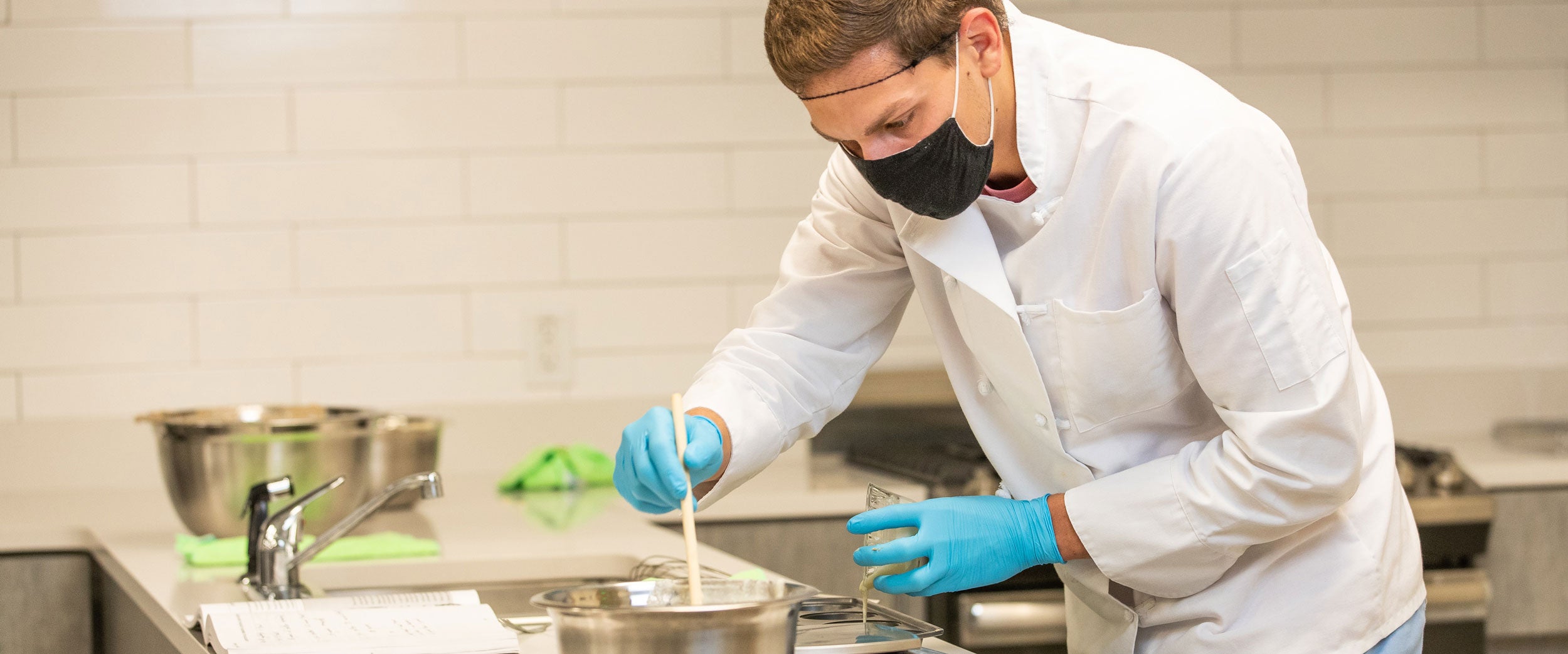 A B.S. in Nutrition and Food Science student mixes multiple food samples in a laboratory at Georgia Southern