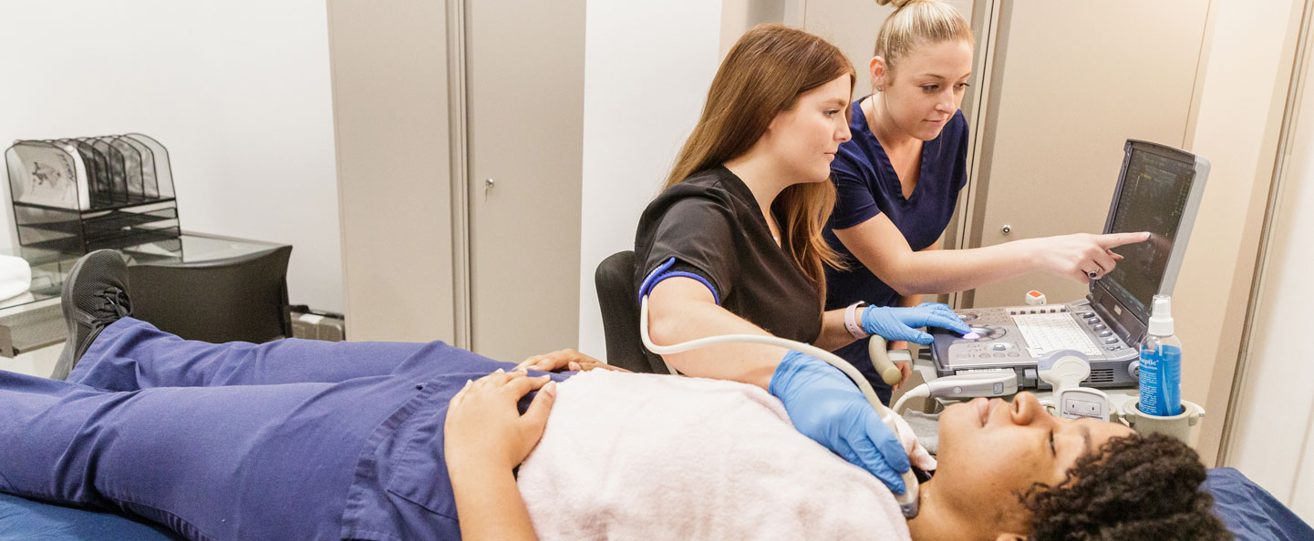 A student in Georgia Southern's B.S. in Radiologic Sciences program practices using imaging equipment on another student in a simulated clinical setting.