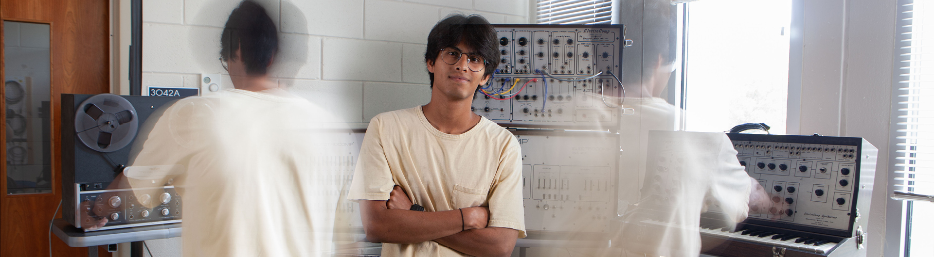 A student in Georgia Southern's Honors College moves between synthesizers and recording equipment in a recording studio