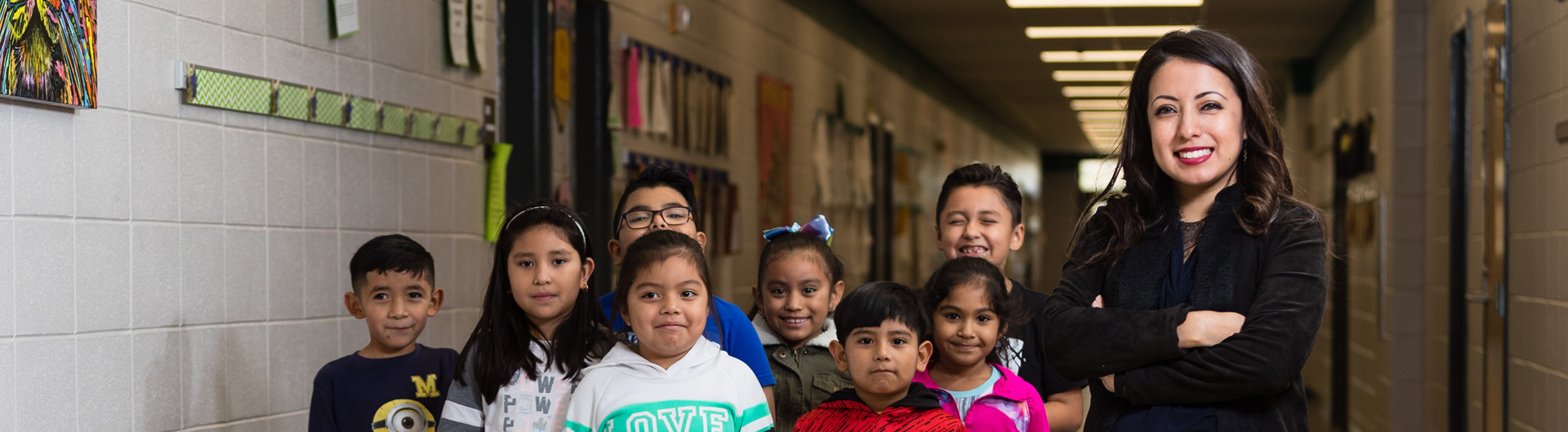 A student from Georgia Southern's M.Ed. in Counselor Education program smiles with a group of elementary school students in a hallway