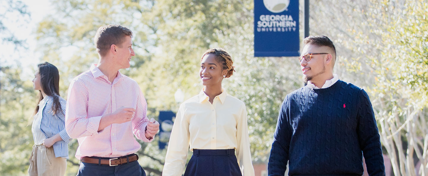 Three students from Georgia Southern's M.Ed. in Higher Education Administration program converse as they walk through campus