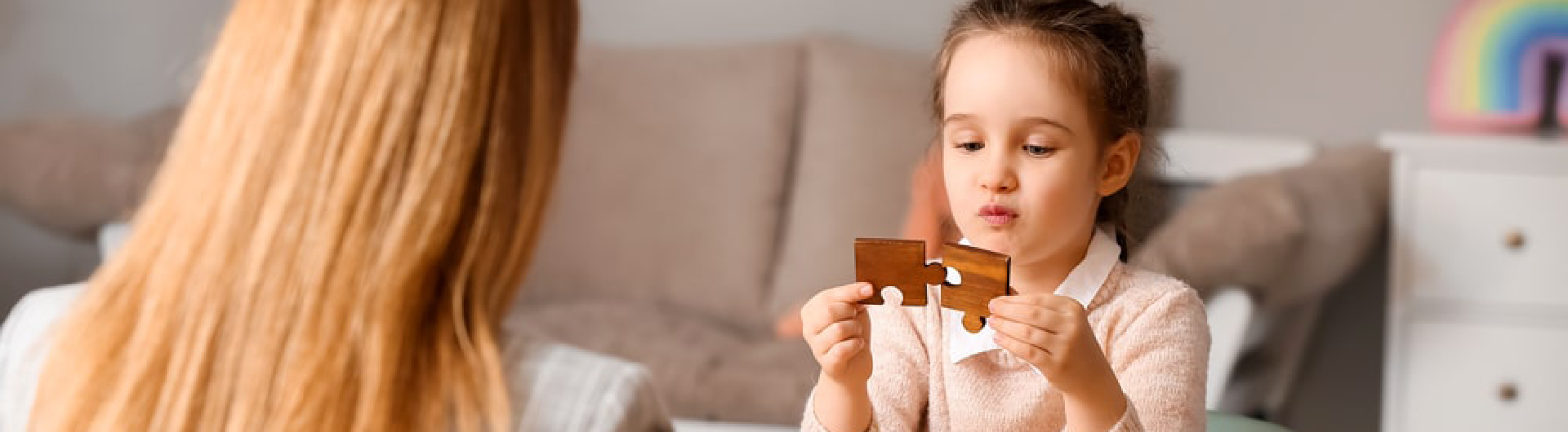 In a clinical setting, a student from Georgia Southern's M.S. in Psychology, Behavior Analysis observes a child patient solve a puzzle.