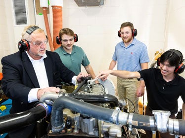 A faculty member discusses a system of pipes and tubes to a group of Georgia Southern B.S. in Construction Management students.