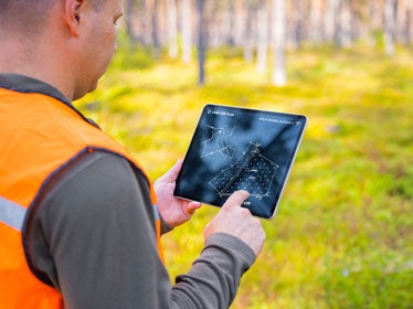 A Georgia Southern B.S. in Construction Management student uses a tablet to assess the landscape in preparation for Land Surveyor Intern Certification.