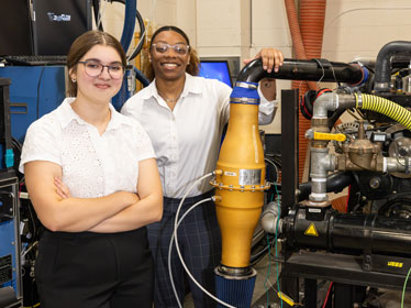 Two Georgia Southern B.S. in Construction Management students proudly stand near a system they constructed.