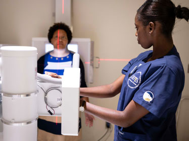 A student from Georgia Southern's B.S. in Radiologic Sciences program positions imaging equipment on a patient during a clinical assignment.