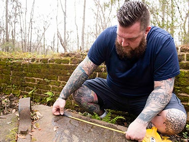 A Georgia Southern Department of History student measures part of a building at a local historical site.