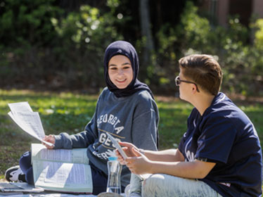 Two Georgia Southern Department of Political Science and International Studies students have a discussion while sitting in the grass