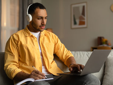 A Georgia Southern graduate student enrolled in an online degree program watches a lecture from home on their laptop.