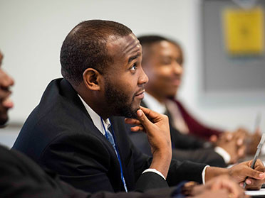 Wearing suits, graduate students from Georgia Southern's Parker College of Business listen intently during a lecture.