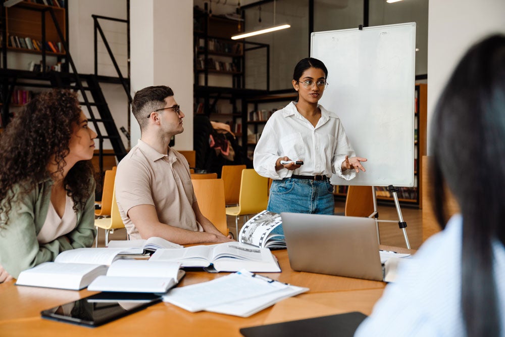 georgia southern students gathered in a common workspace, ideating on a whiteboard about public affairs