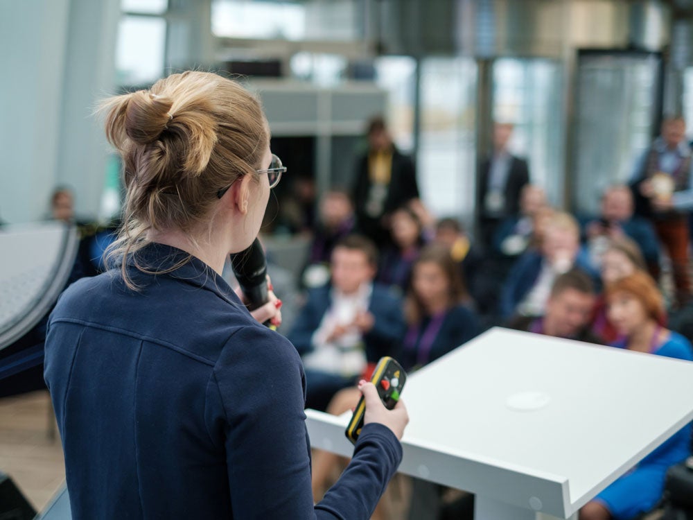 georgia southern student delivering a speech with a microphone, in a professional and corporate setting