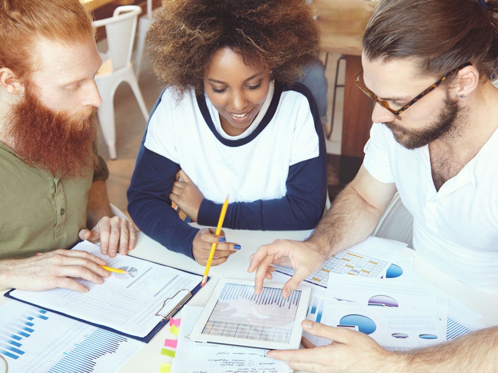 group of georgia southern students collaborating at a desk, discussing ideas and public affairs