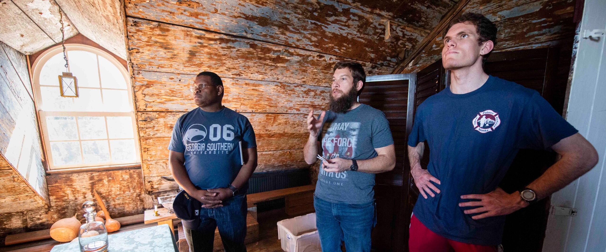 Georgia Southern students standing in a historical exhibit, learning and discussing historical account