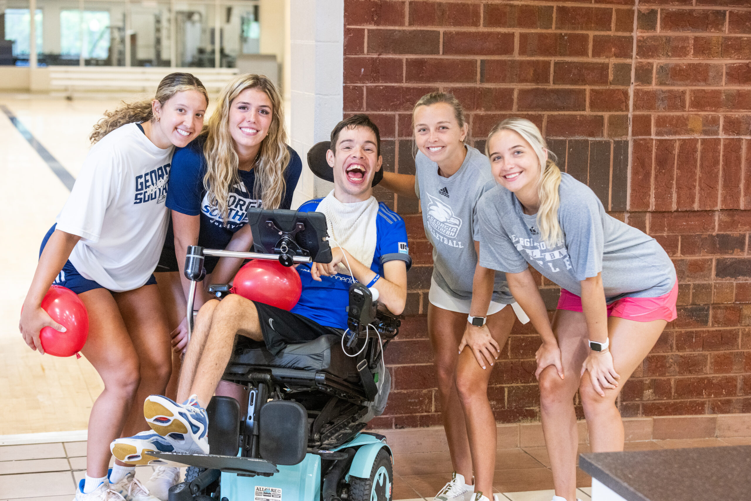 A Camp RAD participant with members of the Georgia Southern Women's Volleyball team.