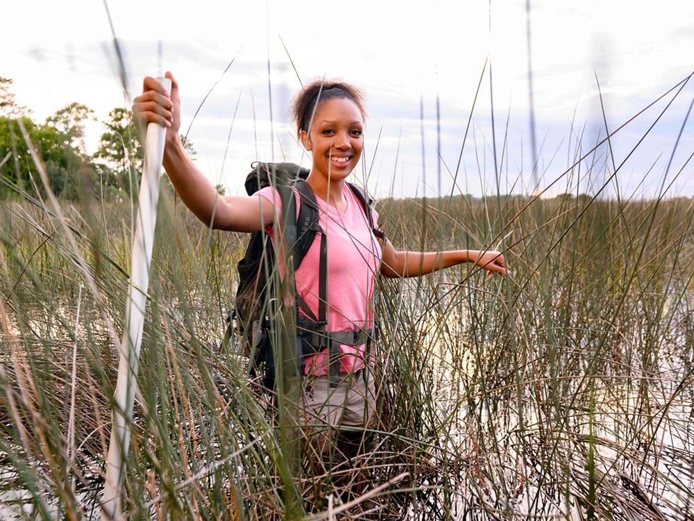 A student from Georgia Southern's M.S. in Biology program hikes through a coastal regio