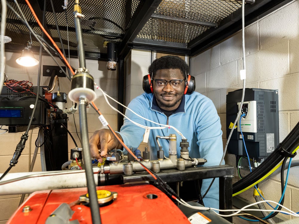 A student from Georgia Southern's M.S. in Mechanical Engineering program wears hearing protection while using equipment in an applied learning environment