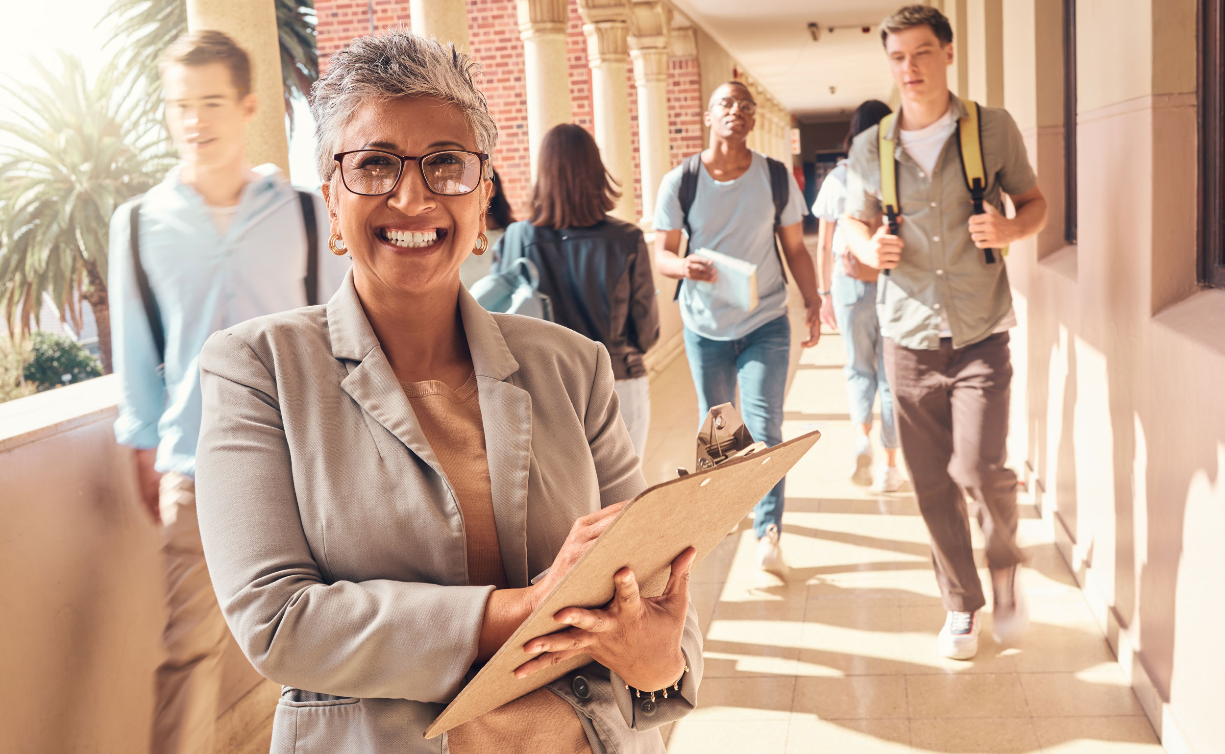 A professor from Georgia Southern's EdD: P-12 and Higher Education Program program smiles in an outdoor hallway as students pass