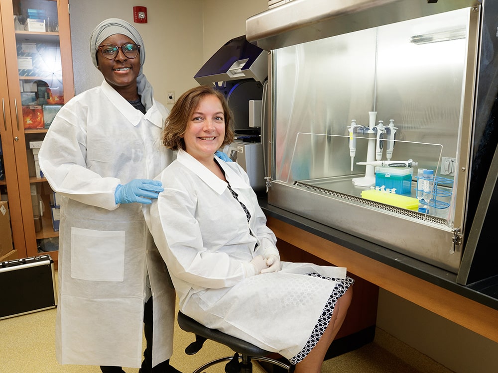 Dr Aslan and a student pause for a photo in the lab