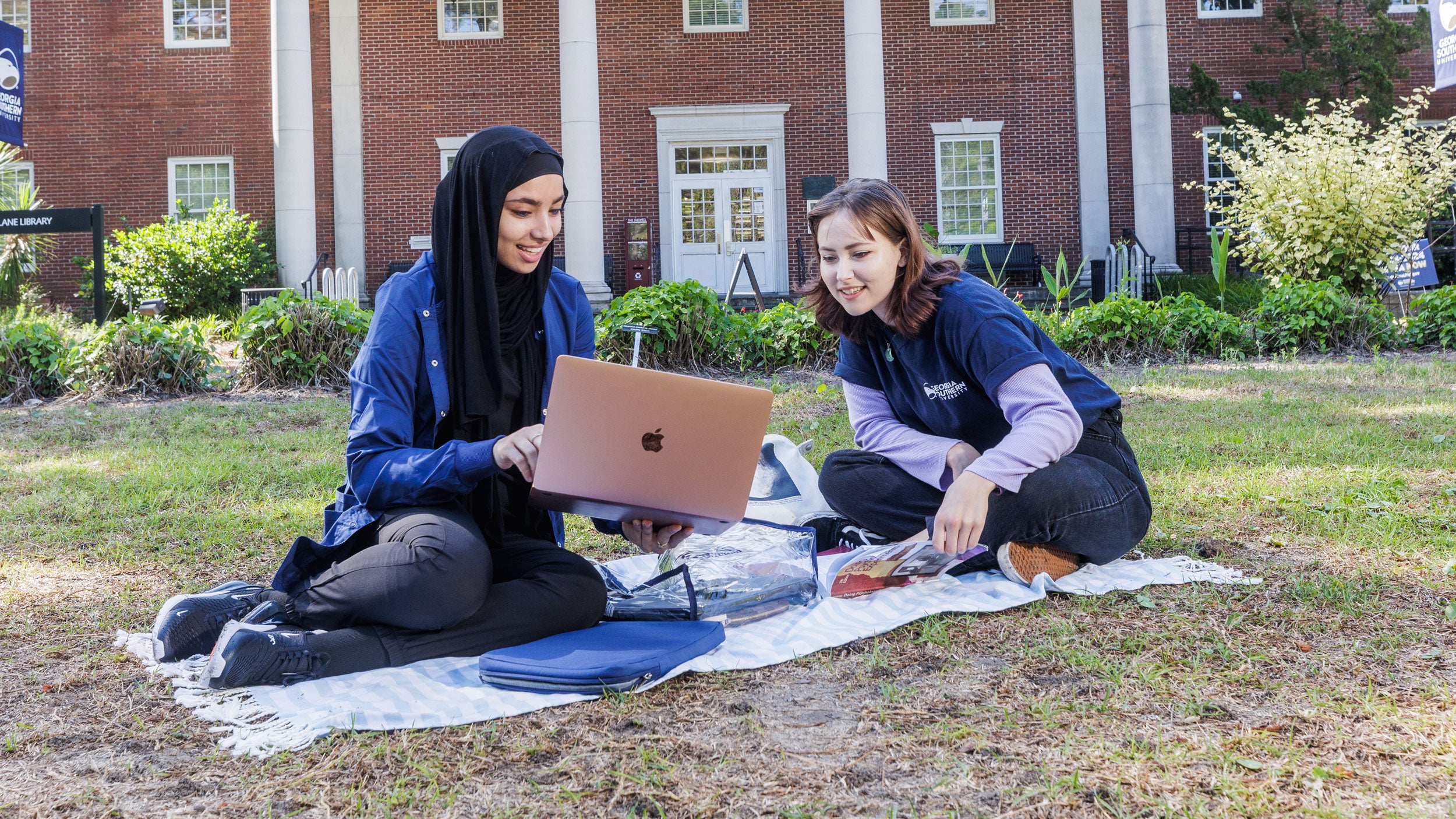 Georgia Southern students sitting outside of academic building studying arabic language.