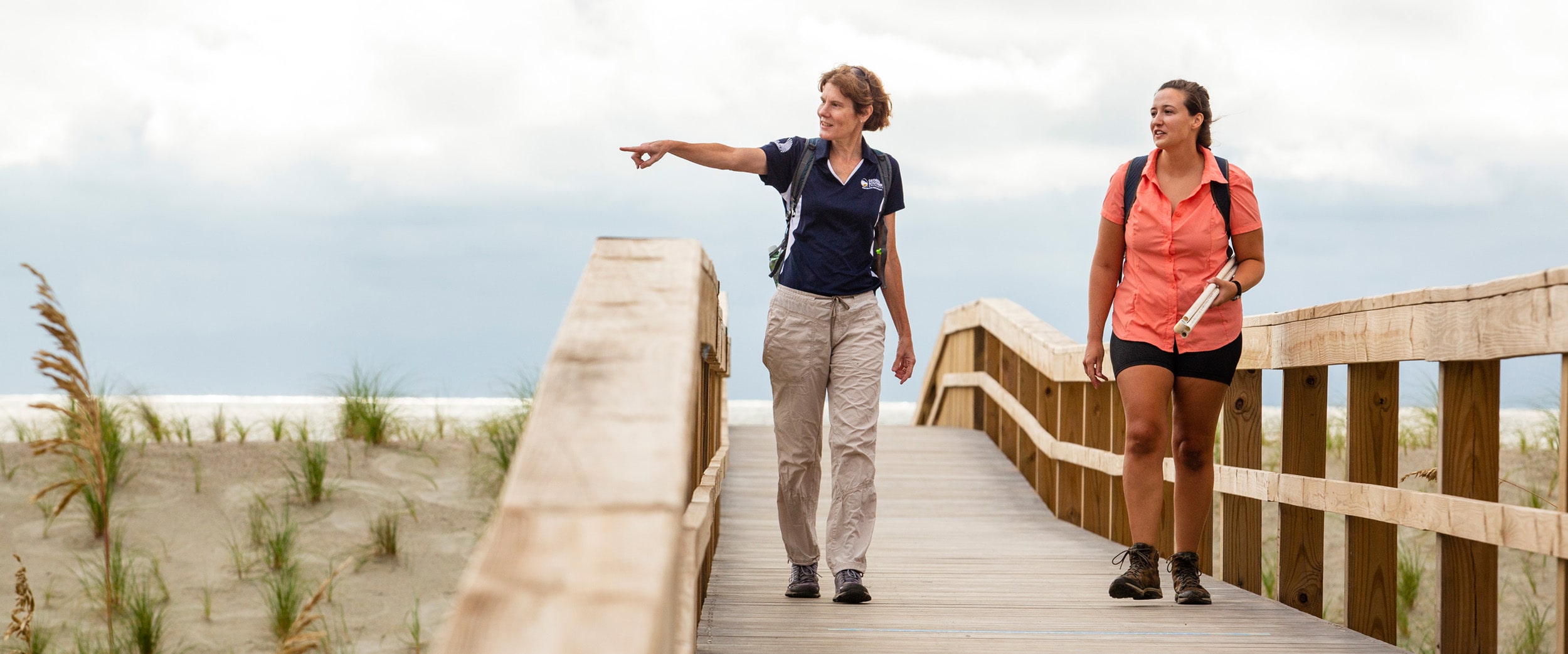 While walking with a student from Georgia Southern's M.S. in Biology program, a faculty member points to an inland area during a coastal research trip