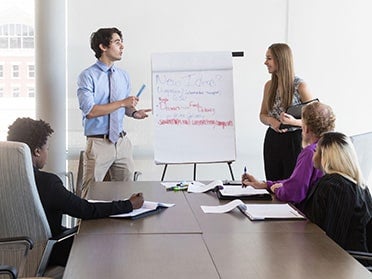 Two BBA in Economics students from Georgia Southern make a presentation to a conference room of business professionals during an internship