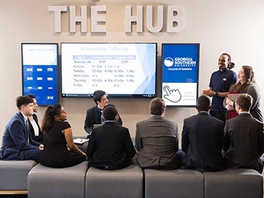 A group of new BBA in Economics students meet with two older students in a common area at Georgia Southern