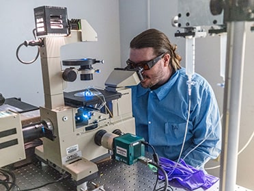 A researcher uses a high-powered microscope.