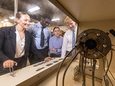 Georgia Southern B.S. in Mechanical Engineering students wearing business dress practice using equipment in an on-campus lab