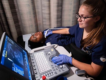 In preparation for a clinical assignment, a B.S. in Radiologic Sciences, Diagnostic Medical Sonography student practices using ultrasound equipment on another student