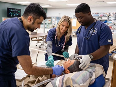 Practicing on a manikin, three students from Georgia Southern's B.S. in Respiratory Therapy program learn to analyze patient breathing