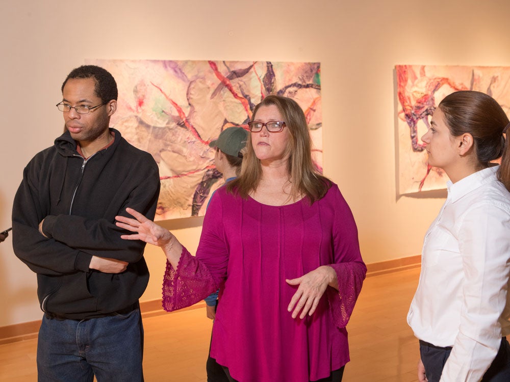 georgia southern students admiring and discussing art exhibit in art gallery