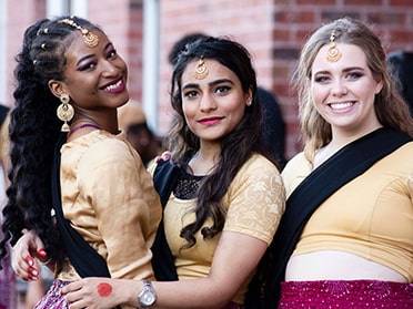 Three students smile for the camera during one of Georgia Southern's on-campus cultural events