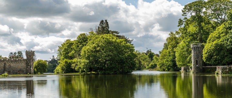 A placid lake divides turreted stone masonry fortress walls that run right up to the water's edge.