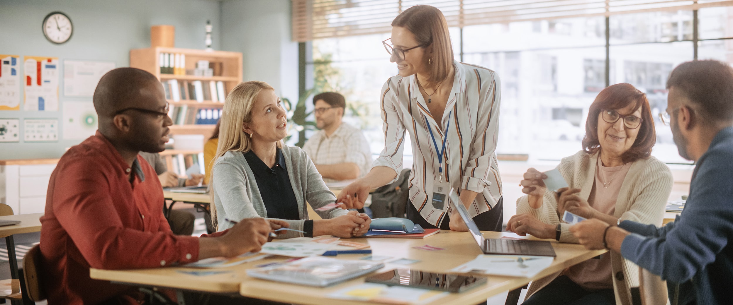 A professor meets with students from Georgia Southern's Teacher Support and Coaching Endorsement program who are sitting around a table