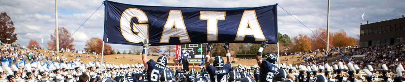 Georgia Southern Eagles football team carry a huge GATA banner as they run onto the field.