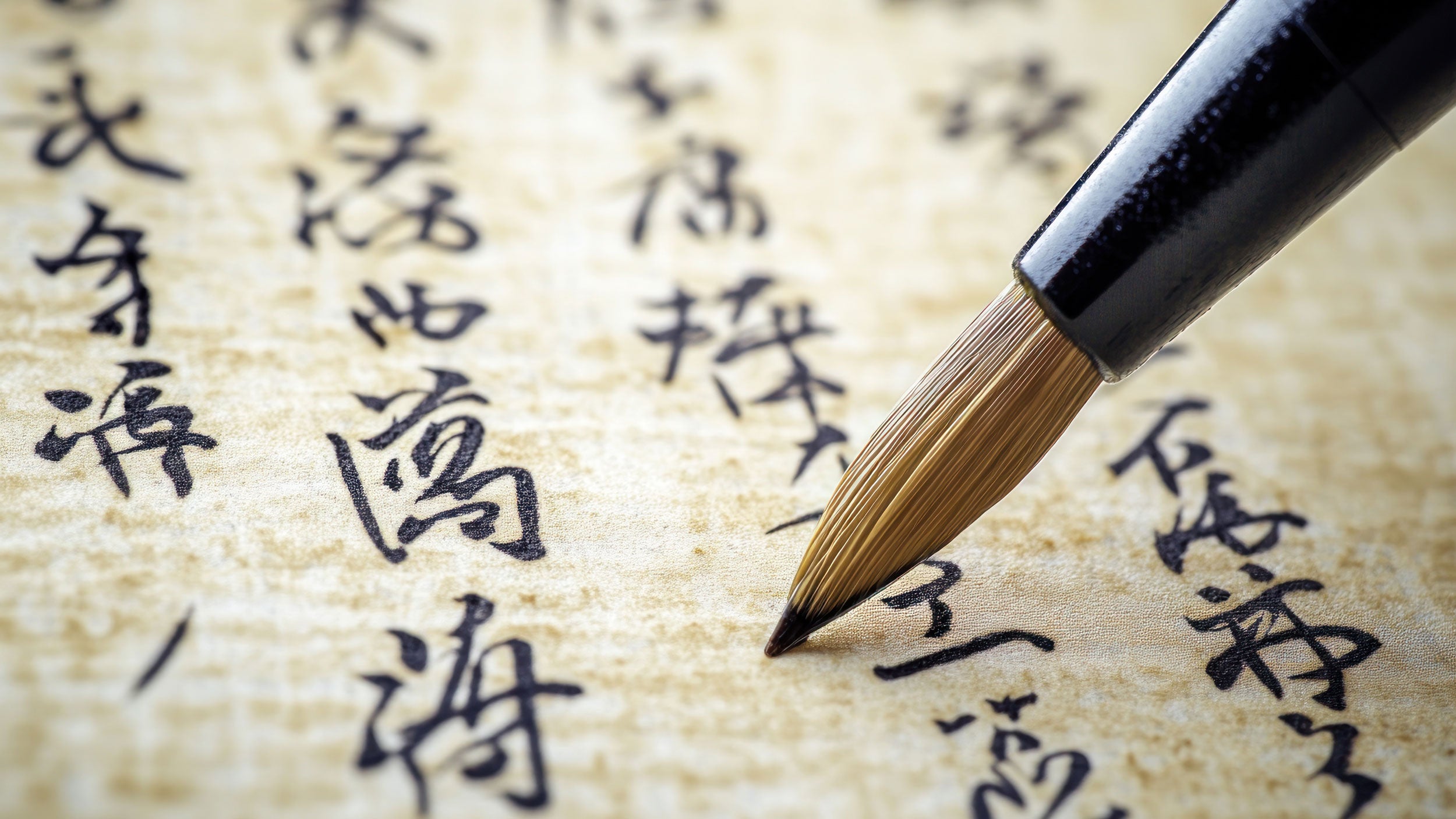 Georgia Southern student using a pen to write chinese caligraphy.